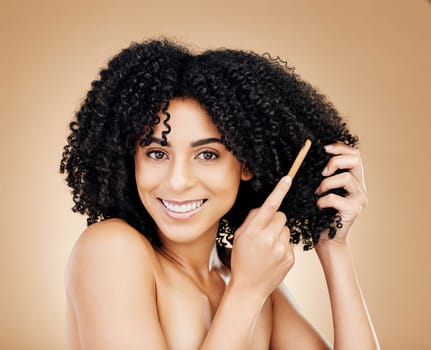 Afro, hair and brush with portrait of woman in studio for beauty, natural growth or coil texture on brown background. Happy model, curly haircare or comb tools of healthy treatment, aesthetic or care