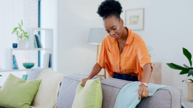 Woman, cleaning and housework in living room, pillow and tidy and organized or neat on furniture. Black person, domestic and chores for hygiene and sanitary cleanup for fresh home and apartment