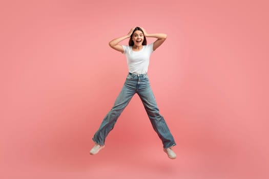 Crazy Sales. Funny Cute Teen Girl Jumping Over Pink Studio Background