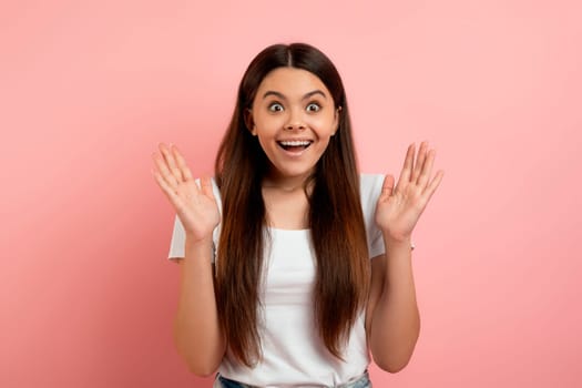 Surprised teenage girl saying wow while posing in studio