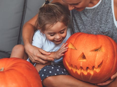 Mother with son curving pumpkin for Halloween