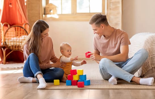 Activities With Babies. Parents Playing Building Blocks With Infant Child At Home