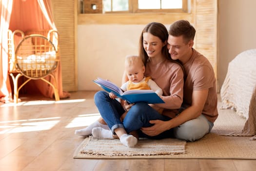 Early Education For Kids. Parents Reading Book To Infant Son At Home