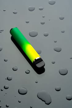 Electronic cigarette on black background with water drops