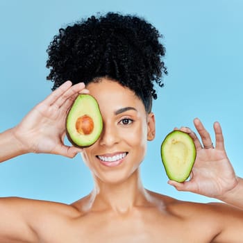 Happy woman, portrait and avocado for skincare, diet or natural beauty against a blue studio background. Face of female person smile with organic fruit for nutrition, vitamin C or skin wellness.