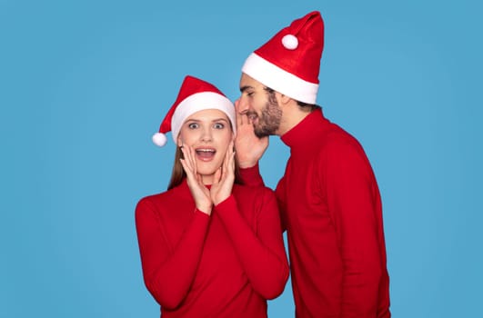 Christmas Offer. Young man whispering secret to his surprised wife