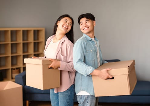 Asian Spouses Posing With Boxes Holding Belongings Moving in Home