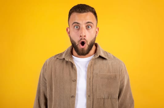Shocked millennial caucasian guy with beard in casual with open mouth