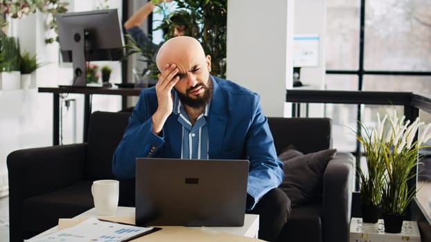 Analyst working with headache in office