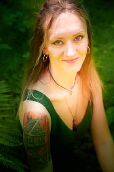 Kirov, Russia - June 29, 2022: Portrait of girl with Tattoo looking as peautiful seductive dryad. Pagan spirit of the forest. Concept of environmental friendliness and caring for nature