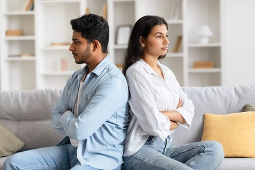Angry Indian couple back-to-back post quarrel on sofa