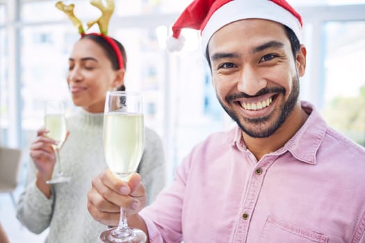Man, champagne and portrait at Christmas, office and party with celebration drink with cheers with friends. Excited person, xmas and glass for alcohol, sparkling wine and happy at event for holiday.