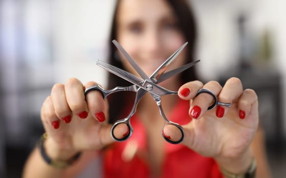 Hairdresser holds working scissors with comb in his hands. Training courses for the profession hairdresser concept