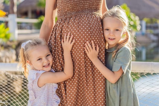 Sisters' love blooms as they tenderly embrace their mother's pregnant belly, sharing anticipation and affection for their soon-to-arrive sibling