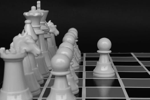 Selective view of chess pawn moving toward for battle with black and white background. Strategy and tactic concept