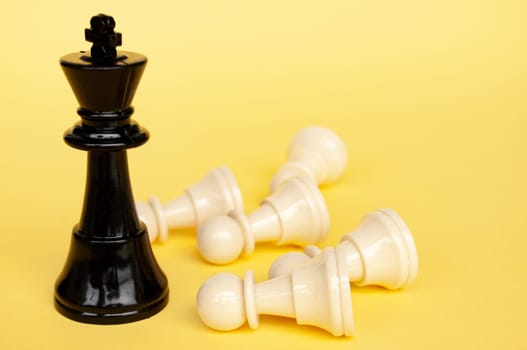 Selective view of chess king defeated white pawn with yellow cover background. Strategy and tactic concept