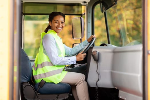 Professions Concept. Portrait Of Young Black Female Driver Posing In Bus