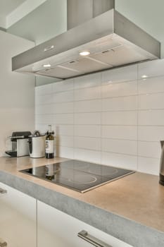 a kitchen with a stove and a white tile wall