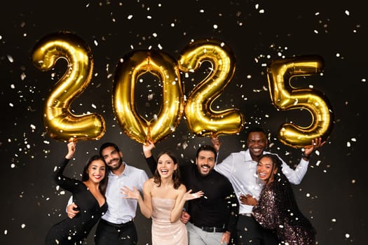 Happy multiracial people three loving millennial couples wearing nice outfits celebrating new year 2025 together on black background, holding golden number baloons and smiling at camera