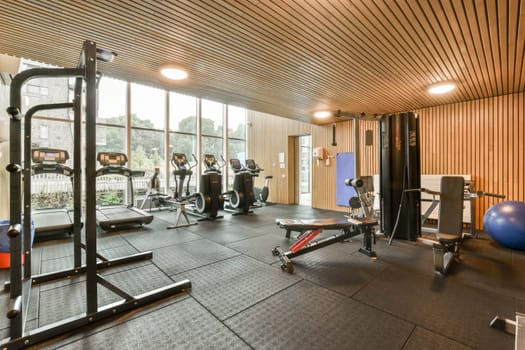 a gym with a lot of exercise equipment and windows