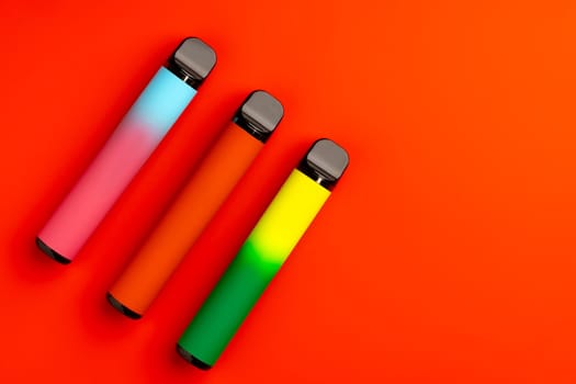 Disposable electronic cigarettes on red background close up