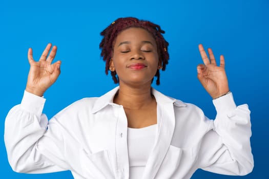 Young afro woman relax with closed eyes against blue background