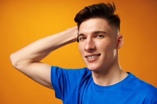 Portrait of a young handsome man, teenager against yellow background