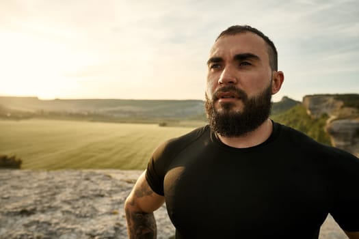 Young bearded man portrait outdoors in the mountains