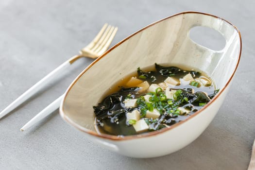 Japanese miso soup in a white bowl on the table