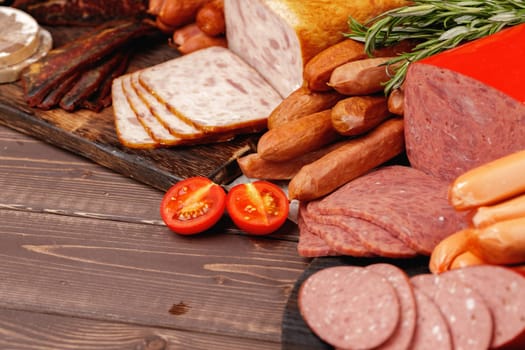 Assortment of meat and sausage on wooden surface