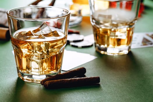 Cuban cigar, whiskey glass and chips on table