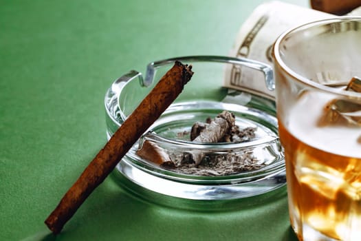 Cuban cigar and money on green background