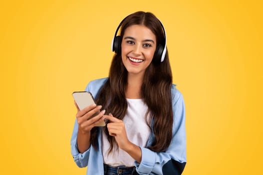 Happy teen student with smartphone, upbeat student lifestyle with headphones, watch video lesson