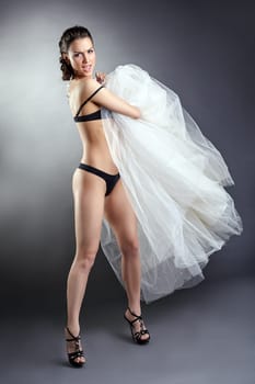 Pretty undressed girl posing with wedding dress