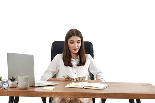 businesswoman working on laptop and holding money