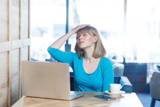 Sad upset despair woman working on laptop, making facepalm gesture, has problems with work.