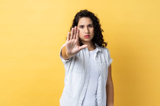 Woman showing stop gesture with palm of hand, trying to stop abuser, rejection, domestic violence.