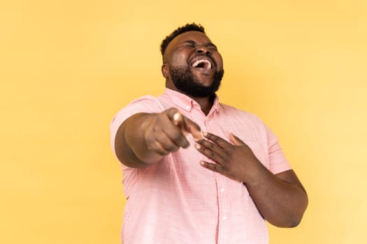 Man laughing out loud holding belly and pointing finger on you, mockery