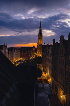 Beautiful old town in Gdansk at summer dusk Poland. Sunset night view from the window rooftop on historical centre Dluga street and city hall architecture buildings St Mary Basilica. Travel attraction tourist destination Dramatic sky