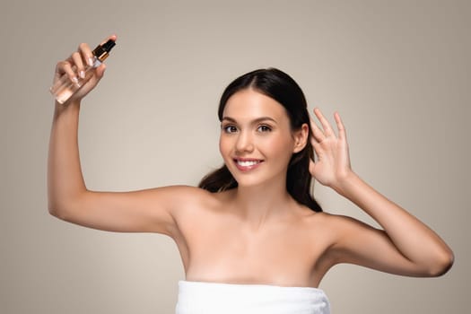 Positive millennial european woman apply spray on hair or skin, enjoy beauty care