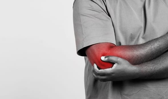 Man holding painful elbow with pain spot on white background