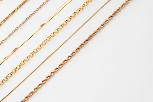 Jewelry set of golden chains on the white background