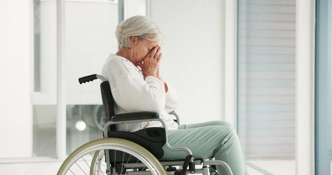 Sad, senior woman and person with disability, wheelchair and crying into hands at the hospital, window or nursing home. Depressed, mental health and elderly person frustrated, thinking in retirement