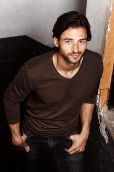 Portrait, fashion and confidence of man in home, apartment or rustic house. Style, casual and handsome, rugged and attractive person in jeans, trendy clothes or standing with hands in pocket in Spain