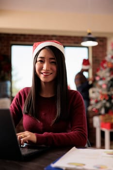 Smiling corporate employee in santa hat