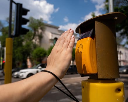 Close-up of a blind woman's hand pressing a button for a traffic light.