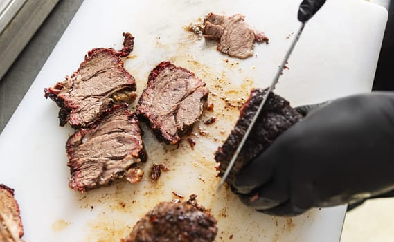Chef hands slicing beef steak 