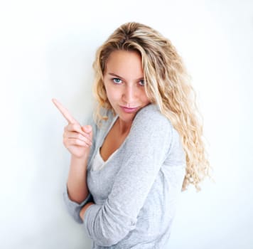 Woman, portrait and pointing finger playful or flirt fun, white wall background as mockup space. Female person, confident and goofy face emoji hand gesture or showing attention, joke humor in Canada