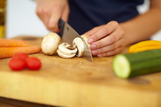 Chef hands, knife and vegetables on chopping board, cooking and preparation at home. Closeup of woman cutting mushrooms in kitchen, organic salad and food for healthy vegan diet, nutrition and dinner