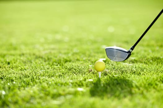 Golf, tee and ball with club on field by ready with swing to hit in hole on driving range in closeup. Sports, training and fitness with challenge for dedication, practice and skill for game in summer
